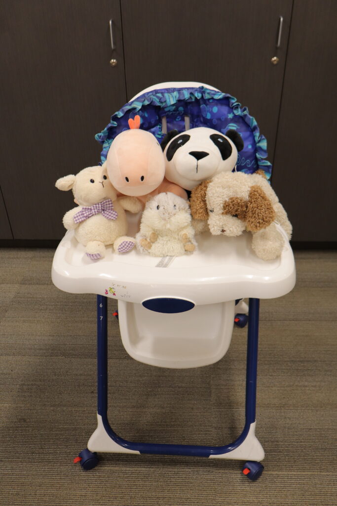 Stuffed animals arranged on a high chair